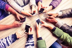 A group of people in a circle checking their smartphones