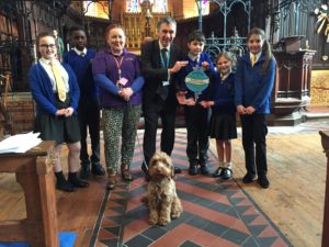 Staff, pupils and Winnie the school dog from St Peter's primary school are presented with the Kent Award by Councillor Rory Love. The presentation is within St Peter's Church.