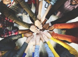 A photo of staff hands all together in a circle from above