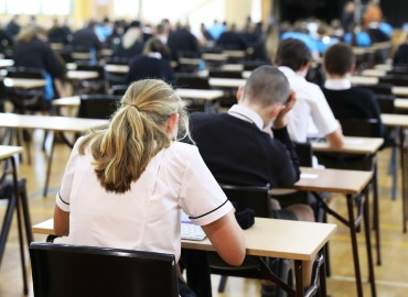 Photo from the back of an exam hall with students sitting an exam