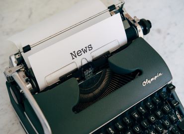 Type writer with the word News typed onto the paper