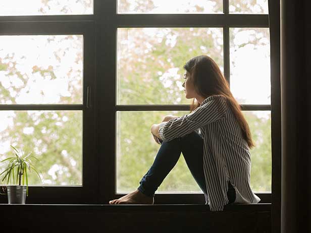 young person looking out of window